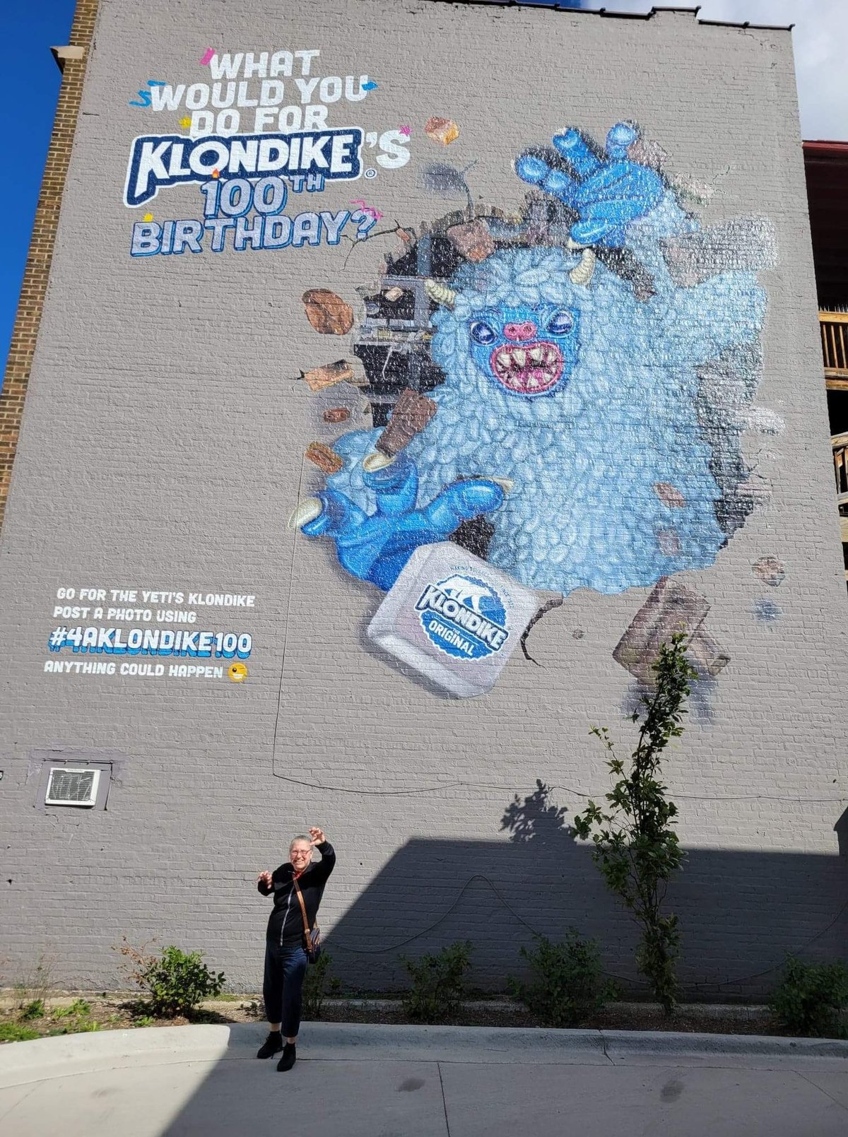 Another visitor clawing the air under the Chicago yeti mural