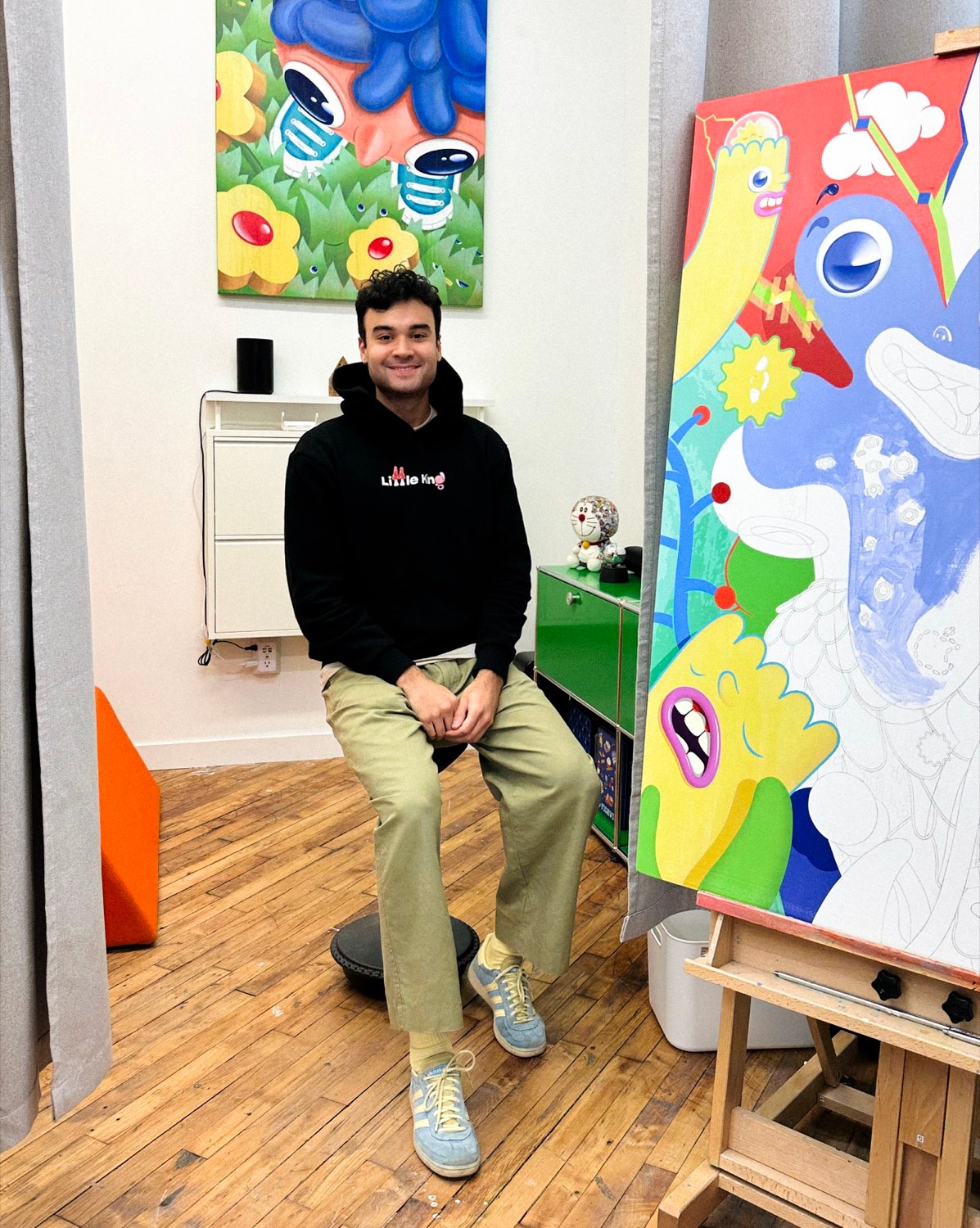 Carlos Miranda in his Brooklyn studio, seated beside a painting in progress