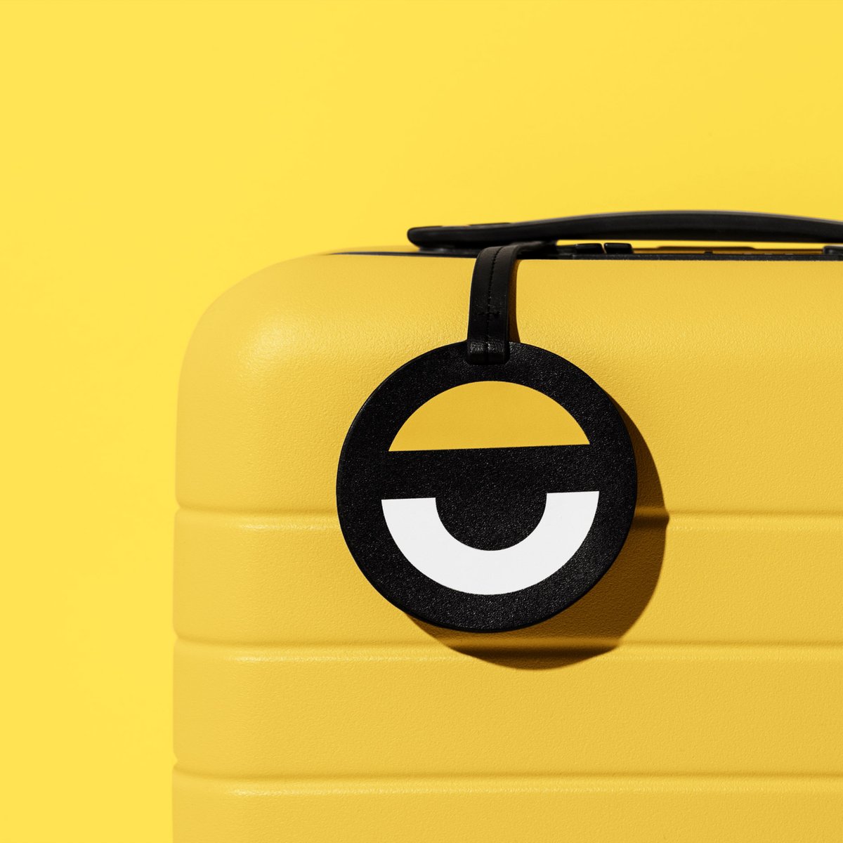 Yellow suitcase with an eye-shaped luggage tag