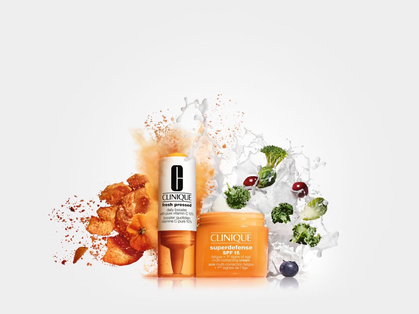 Clinique products bursting from an orange splash with fruit