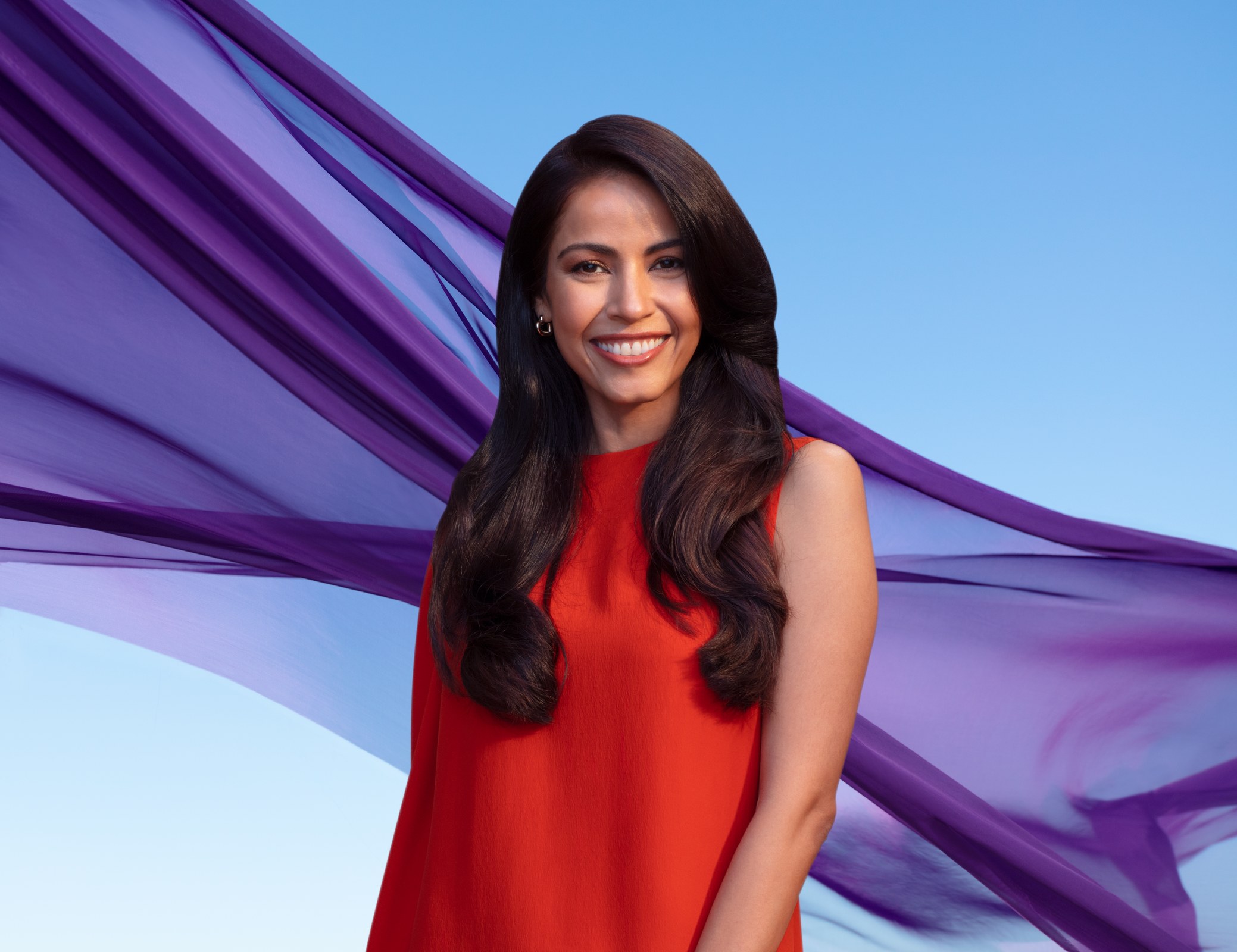 Schwarzkopf campaign: model in red with purple fabric against blue sky