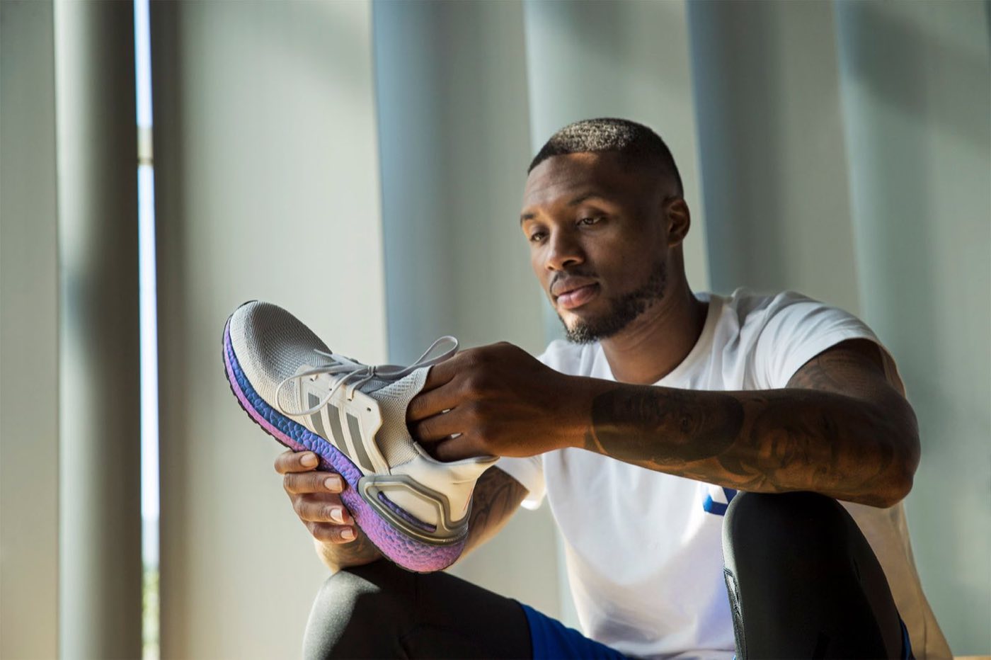 Man holding up a sneaker in soft window light