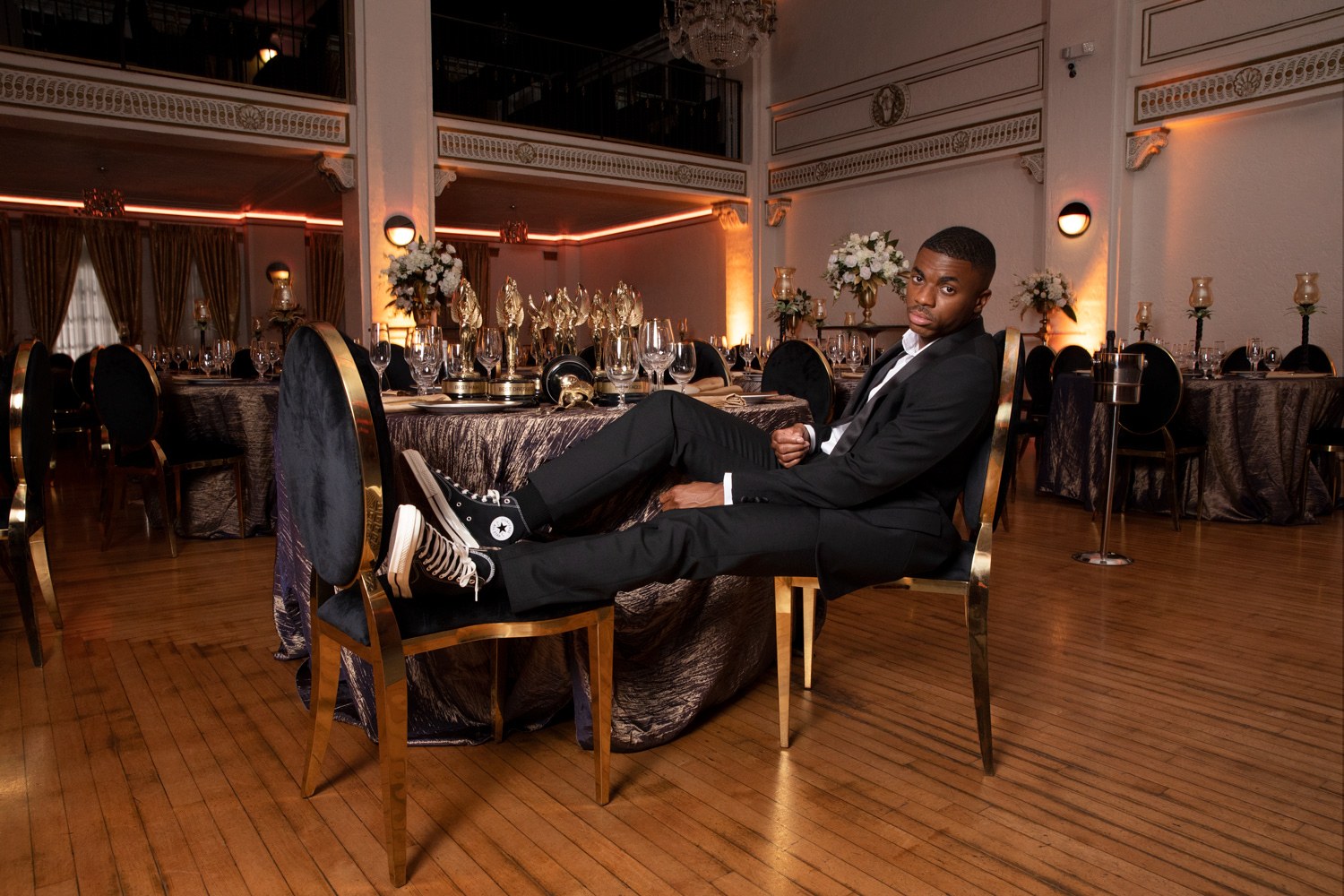 Converse: a man seated in a candlelit ballroom