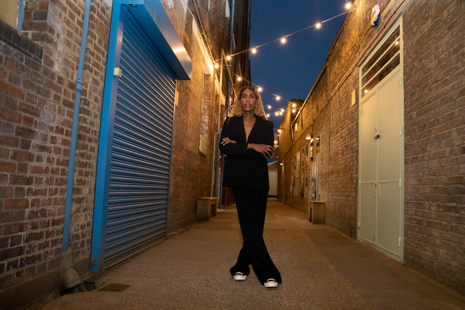 Converse: Honey Dijon standing in a lamplit alley